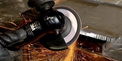 Anfasen einer Metallkante mit einer Fächerschleifscheibe
