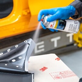 Techniker bereitet das Karosserieteil vor, indem er zuerst Korrosionsschutz aufsprüht